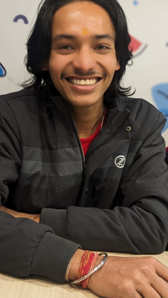 a man smiling wear black jacket have long hairs